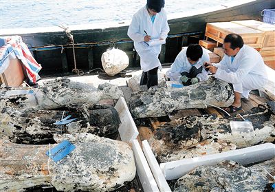 2015年5月，在三沙市永乐群岛珊瑚岛海域，文物考古工作者在对出水石像表面附着物进行采样。